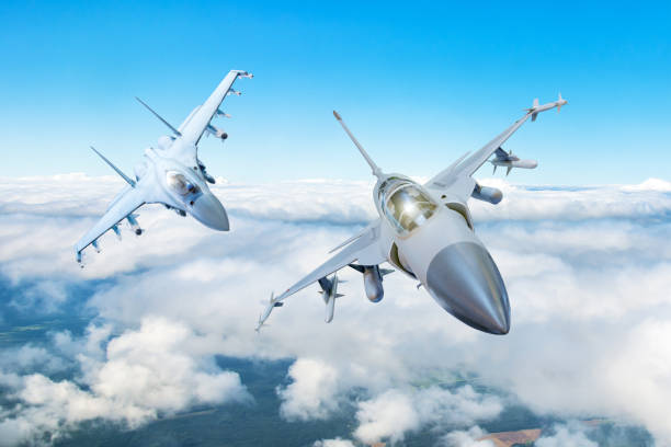Pair of combat fighter jet on a military mission with weapons - rockets, bombs, weapons on wings flies high in the sky above the clouds. Pair of combat fighter jet on a military mission with weapons - rockets, bombs, weapons on wings flies high in the sky above the clouds aerobatics photos stock pictures, royalty-free photos & images