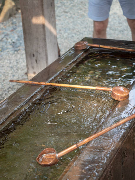 rituale di pulizia temizuya al tempio kōtoku-in a kamakura - hase temple foto e immagini stock