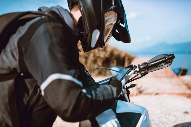 istock Motorcyclist Adjusting the Navigation on Mobile Phone on Lake Side 1035185446