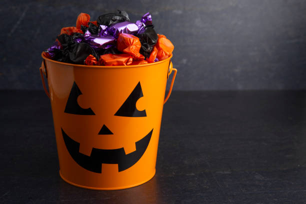 istock Pumpkin Bucket Filled with Various Wrapped Candies 1035188004