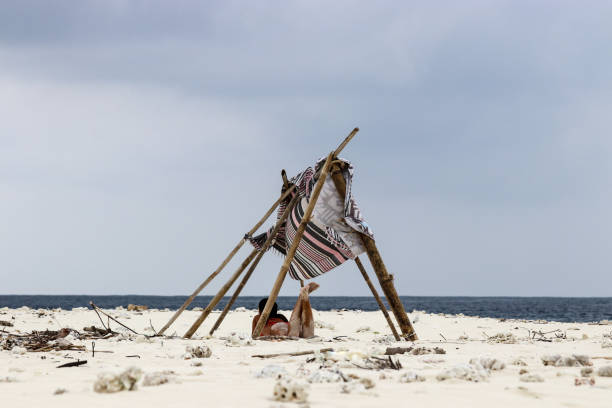 Woman lying on sandy beach on deserted island