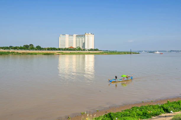 fiume tonle sap con una barca e la strada tonle sap con l'hotel sokha a phnom penh - flood people asia cambodia foto e immagini stock