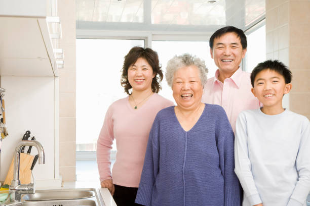 istock Chinese family smiling at camera in kitchen 1035202378