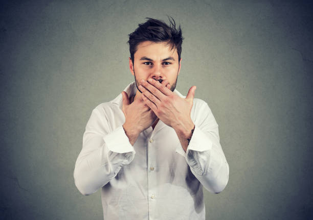 Man covering mouth in restriction to talk