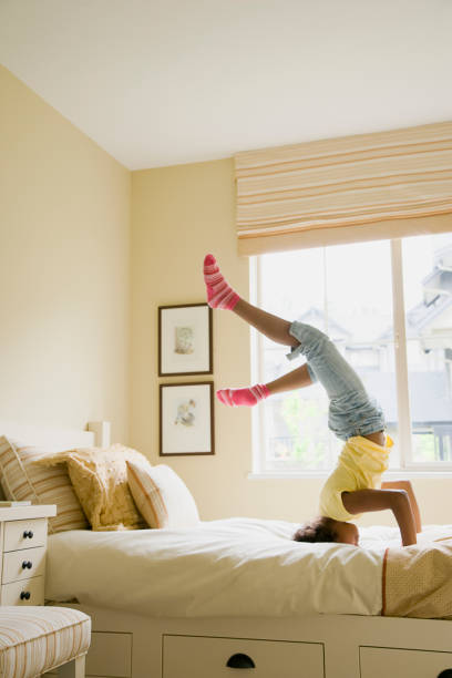 istock African American girl doing headstand on bed 1035219098