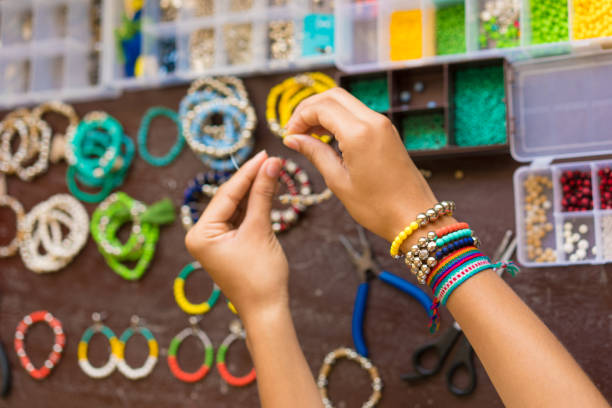 istock Female hands making handmade bijouterie with little balls and stones 1035219550