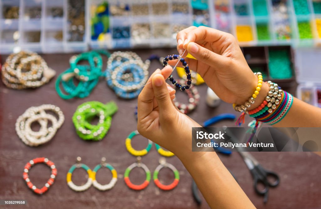 Female hands making handmade bijouterie with little balls and stones Hand, Human Hand, Jewelry, Manufactured Object, Personal Accessory Making Stock Photo