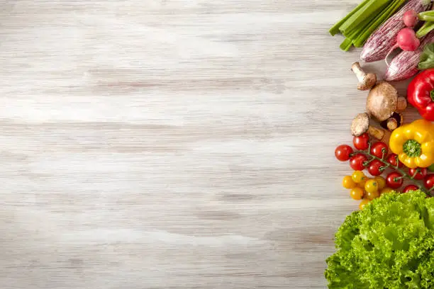 Photo of Fresh and raw vegetables on wooden kitchen table - Copy Space