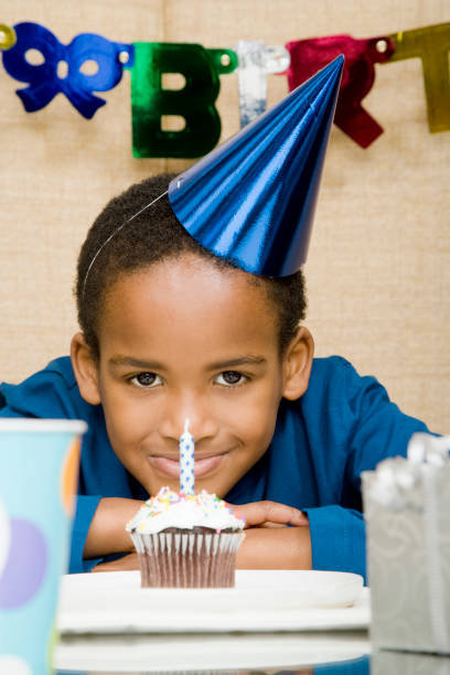 istock African boy with cupcake at birthday party 1035222200