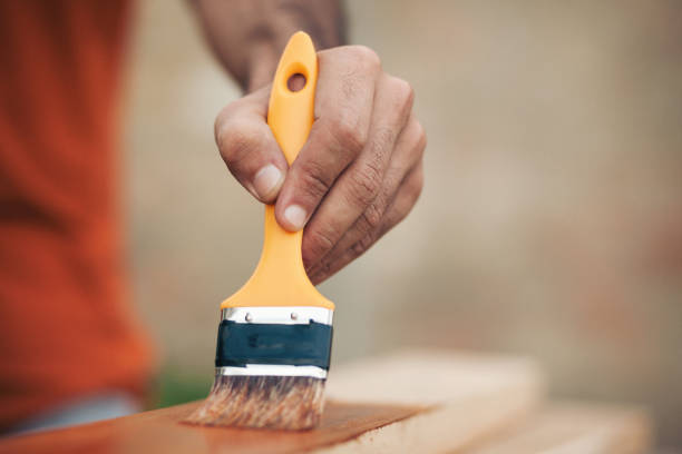 istock Young man painting and fixing wooden board 1035234612