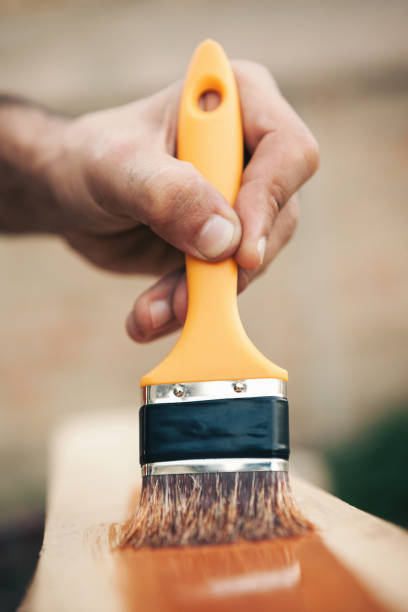 istock Young man painting and fixing wooden board 1035234670