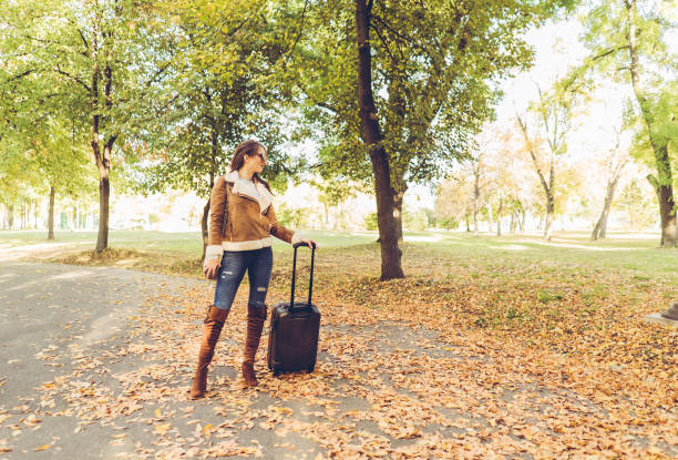 istock Woman with luggage in a park 1035234830