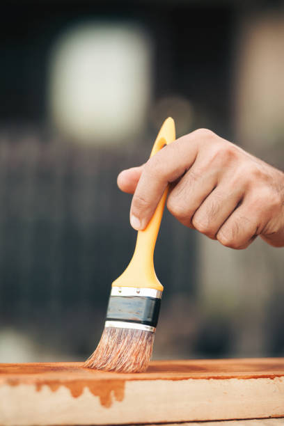 istock Young man painting and fixing wooden board 1035234970