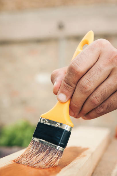 istock Young man painting and fixing wooden board 1035235020