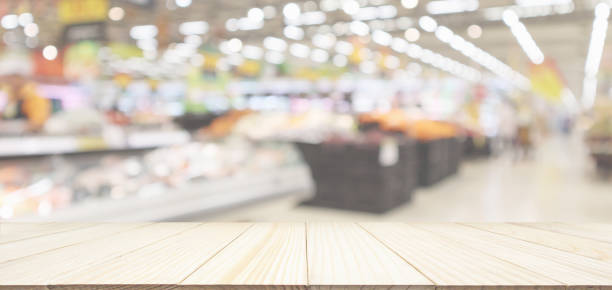 istock Wood table top with supermarket grocery store blurred defocused background with bokeh light 1035265156