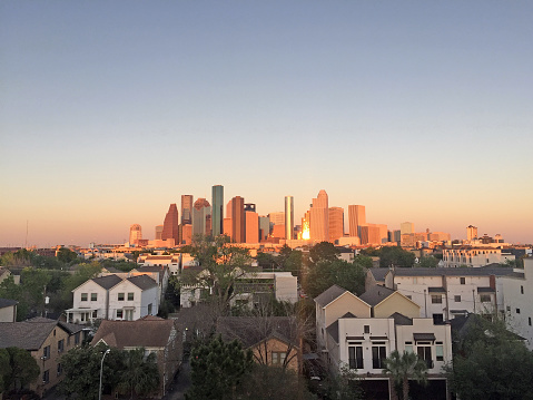 View of downtown Houston during sunset on a clear day with townhouses on the foreground. Viewed from Washington Avenue area