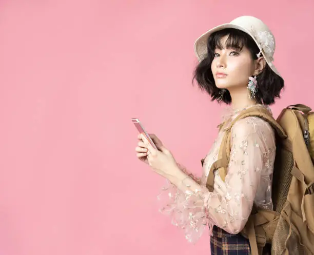 Photo of Travel concept portrait of happy woman asian touris in pink background