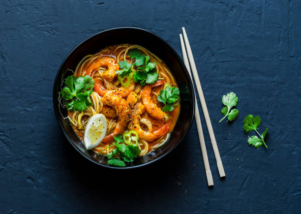 sopa de laksa de camarones de coco sobre un fondo oscuro, la vista superior. copia espacio - comida asiática fotografías e imágenes de stock