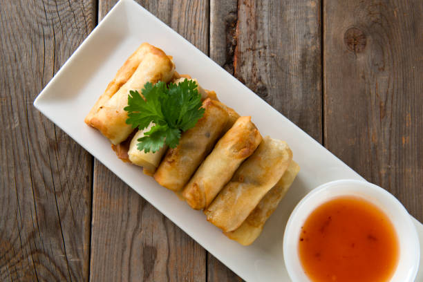 istock Lumpia Spring Rolls on Wooden Table in Restaurant 1035330558