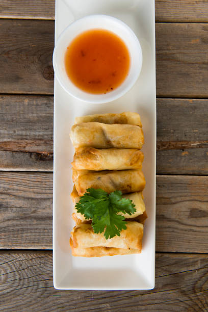 istock Lumpia Spring Rolls on Wooden Table in Restaurant 1035330586