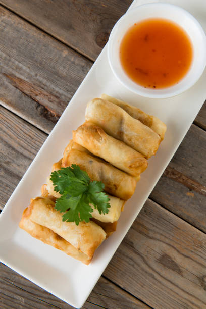 istock Lumpia Spring Rolls on Wooden Table in Restaurant 1035330612