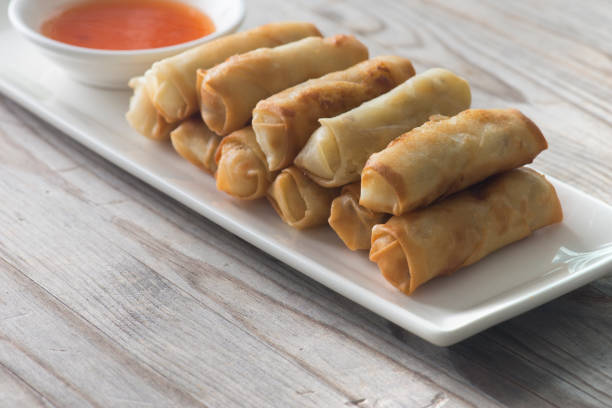 istock Lumpia Spring Rolls on Wooden Table in Restaurant 1035330622