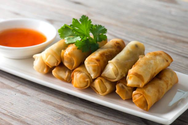 istock Lumpia Spring Rolls on Wooden Table in Restaurant 1035330634