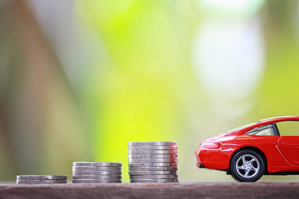 istock Silver coin of pile with red car model. 1035331188