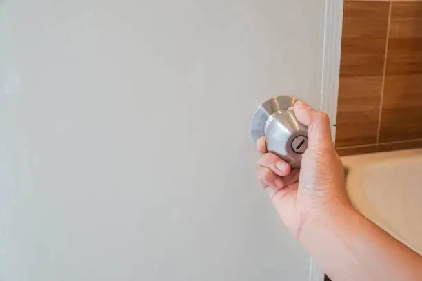 close up women twists doorknob to enter the bathroom