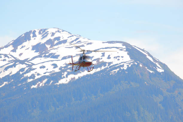A helicopter used for tourism flies over a mountain in remote Alaska