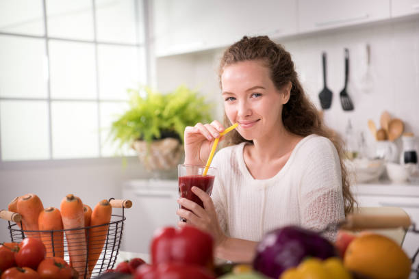 과일 및 야채 주스와 함께 부엌에서 건강 한 젊은 여자 - dieting juice carrot tomato 뉴스 사진 이미지