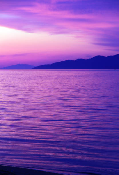 Purple Sunset The rocky shore of Vancouver beach english bay vancouver skyline stock pictures, royalty-free photos & images