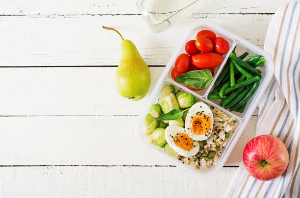 istock Vegetarian meal prep containers with eggs, brussel sprouts, green beans and tomato. Dinner in lunch box. Top view. Flat lay 1035384212