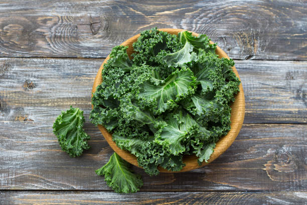 istock Fresh green curly kale leaves on a wooden table 1035390328