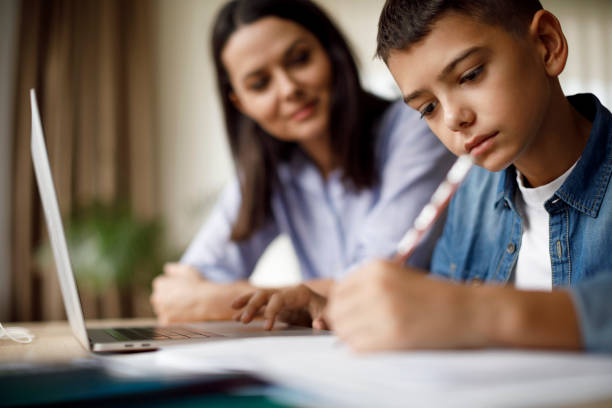 istock Mother helping teenager with homework 1035393604