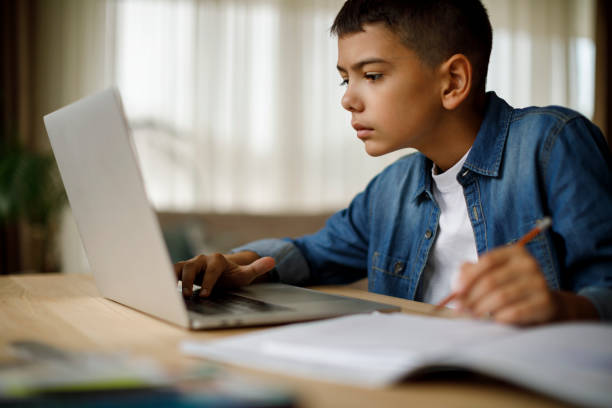 teenager-junge mit laptop für hausaufgaben - mittelschule bücher stock-fotos und bilder