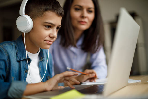 mother and son using laptop at home - parent mother music listening imagens e fotografias de stock