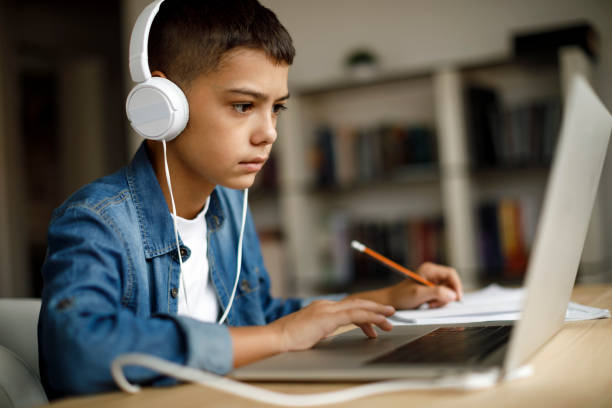 istock Teenage boy listening to music while doing homework 1035394042