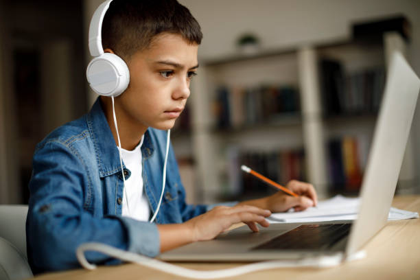 teenage boy listening to music while doing homework - homework pencil people indoors imagens e fotografias de stock