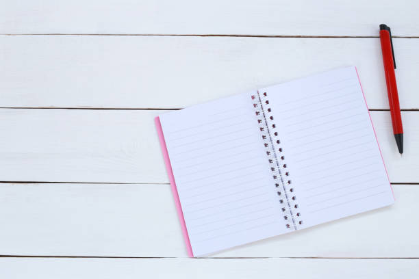istock Book and pen on white wood background. 1035394194