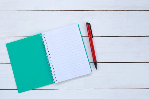 istock Book and pen on white wood background. 1035394232