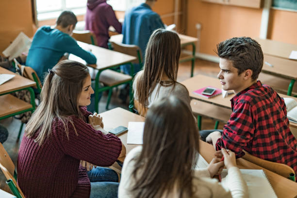 istock High school friends talking during the class in the classroom. 1035407090
