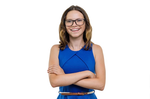 Confident girl student in glasses with arms crossed smiling on white background, isolated.