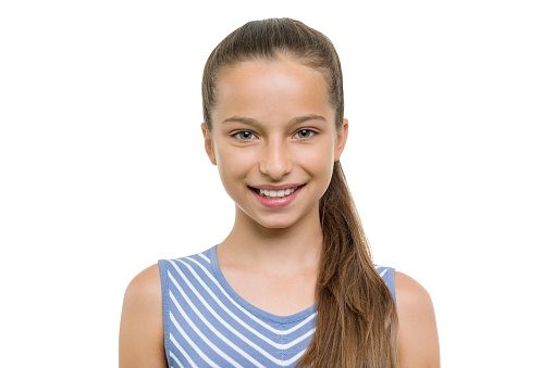 Portrait of beautiful girl of 10, 11 years old. Child with perfect white smile, isolated on white background.
