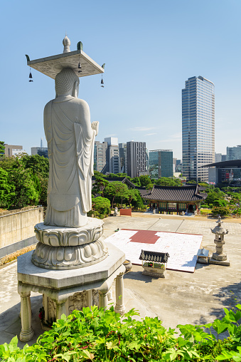 Amazing view of Seoul skyline from Bongeunsa Temple at Gangnam District in Seoul, South Korea. Back view of Buddha statue. Scenic cityscape on summer sunny day.