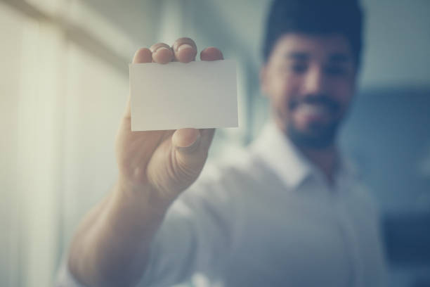 istock African man holding a blank business card. Space for copy. 1035413560