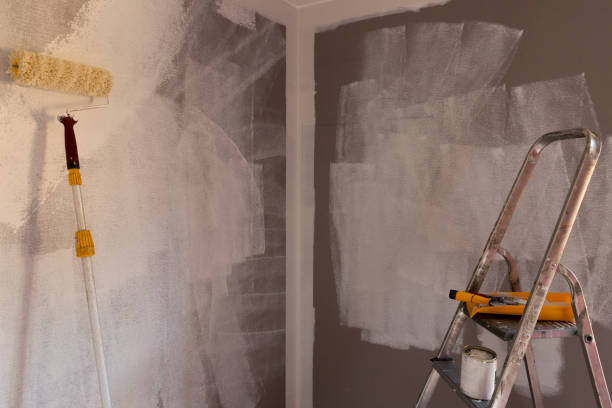 istock Tools for coloring, paint roller, brush, aluminium leader. Wall partly collored. 1035413658