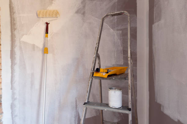 istock Tools for coloring, paint roller, brush, aluminium leader. Wall partly collored. 1035413714