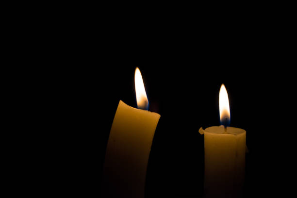istock Two burning candles on black background 1035417642