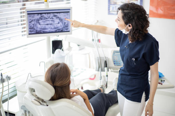 istock Female dentist talking to her patient at dentist's office 1035417834